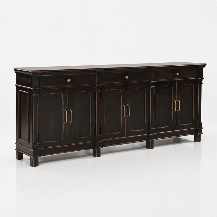 A long black wooden sideboard cabinet with distressed gold-toned trim and brass hardware, shown on a clean white studio background.