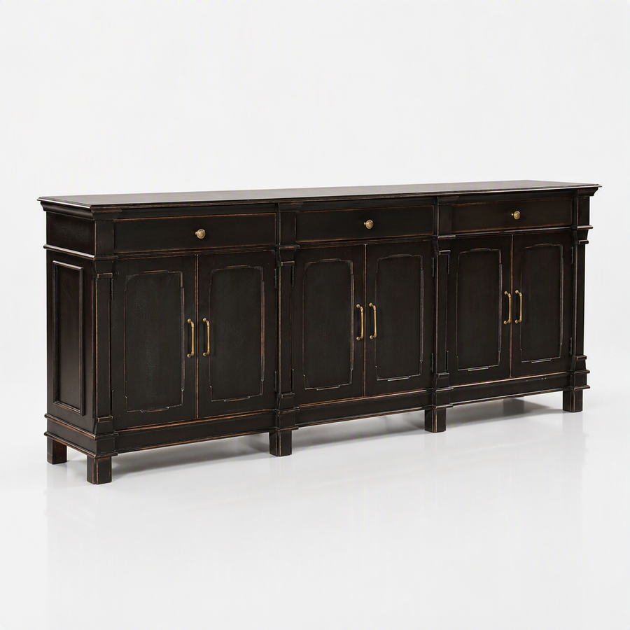 A long black wooden sideboard cabinet with distressed gold-toned trim and brass hardware, shown on a clean white studio background.