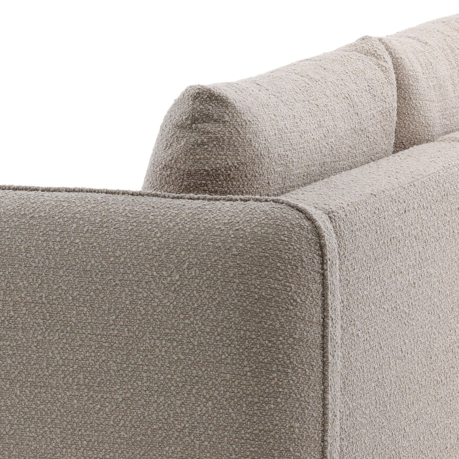 Close-up of a textured beige sofa corner on a white background, neutral tones 