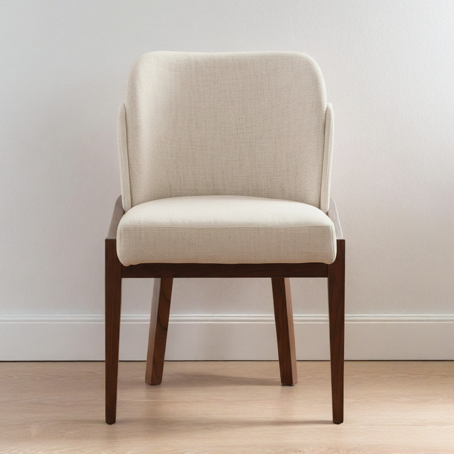 Beige upholstered chair with wooden legs on a light wood floor against a white wall.