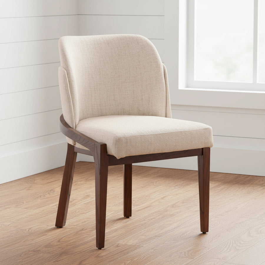 Beige upholstered chair with wooden legs on a wooden floor