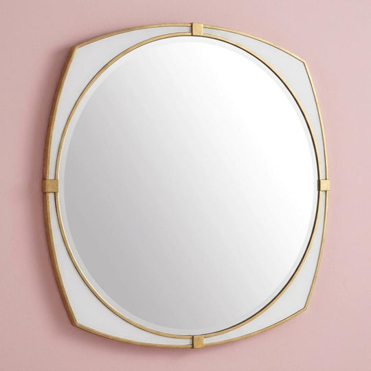 Round mirror with gold frame on a pink background