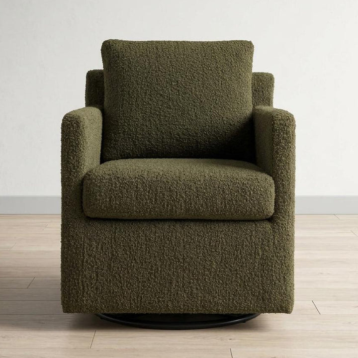 Green textured armchair on a wooden floor with a white wall background