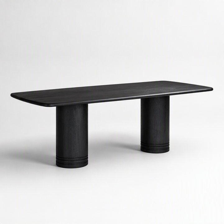 A minimalist black wooden dining table with a rounded rectangular top and two cylindrical pedestal legs, shown against a clean white studio background.