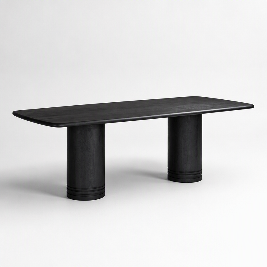 A minimalist black wooden dining table with a rounded rectangular top and two cylindrical pedestal legs, shown against a clean white studio background.