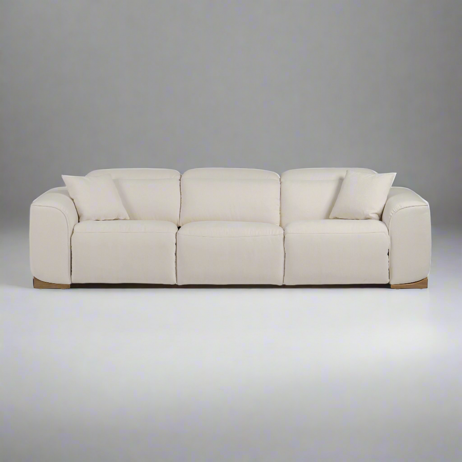 A modern beige fabric sofa featuring plush cushions and two decorative pillows, set against a neutral gray background.