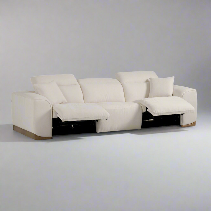 Cream-colored sectional sofa with reclining features and a plush pillow, set against a gray background.