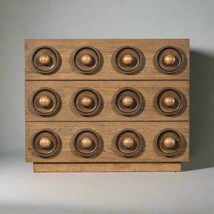 Front view of a wooden drawer chest with a geometric design featuring three rows of circular, recessed patterns and spherical knobs.