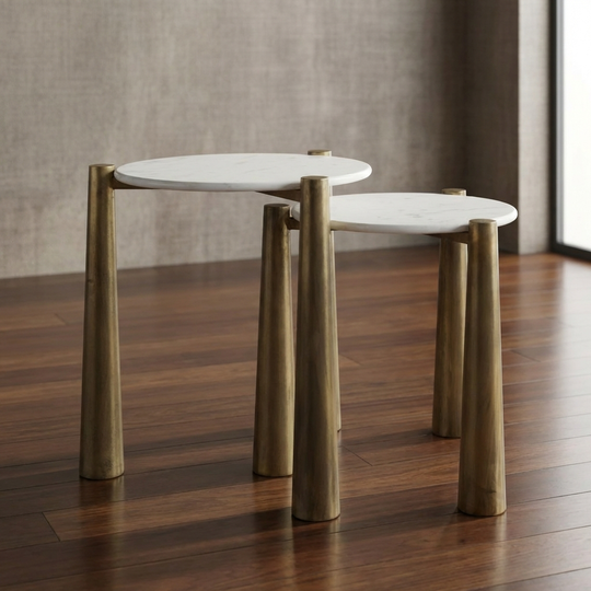 Set of two nesting tables with white marble tops and bronze metal legs on a white background