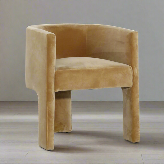 Brown velvet chair on a wooden floor with a neutral background