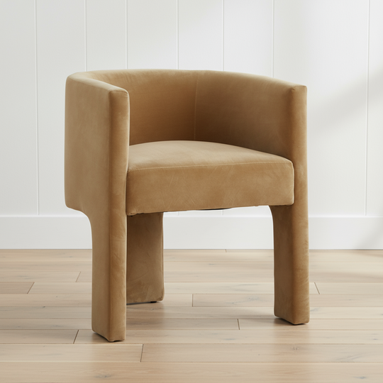 velvet armchair on a wooden floor with a white paneled wall background