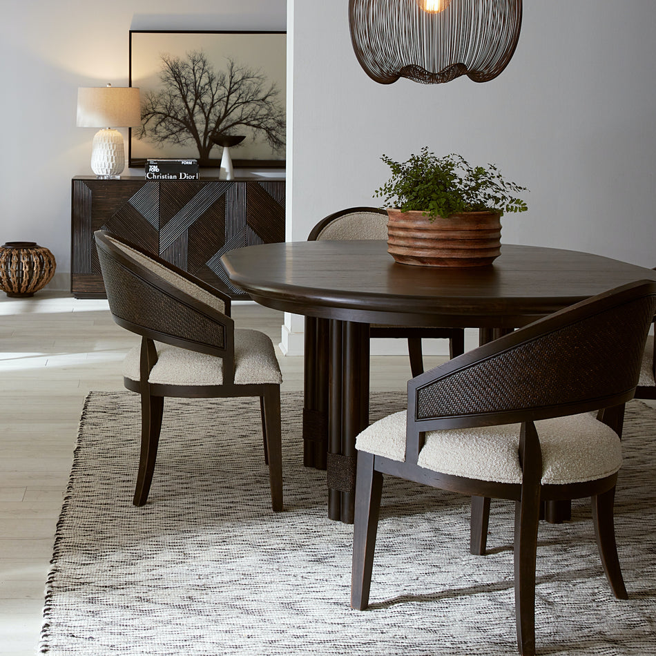 Retreat round dining table with pole rattan and dark wood finish.