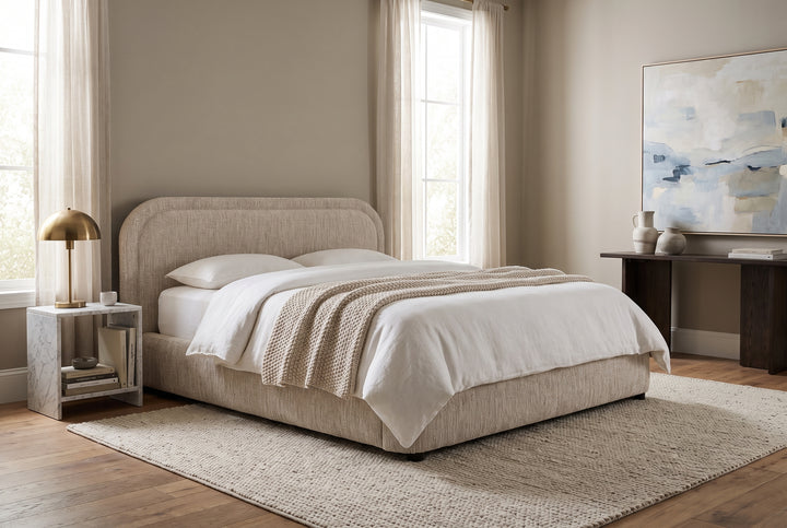 Modern minimalist bedroom featuring a beige upholstered bed, marble side table, and abstract art in a neutral palette.