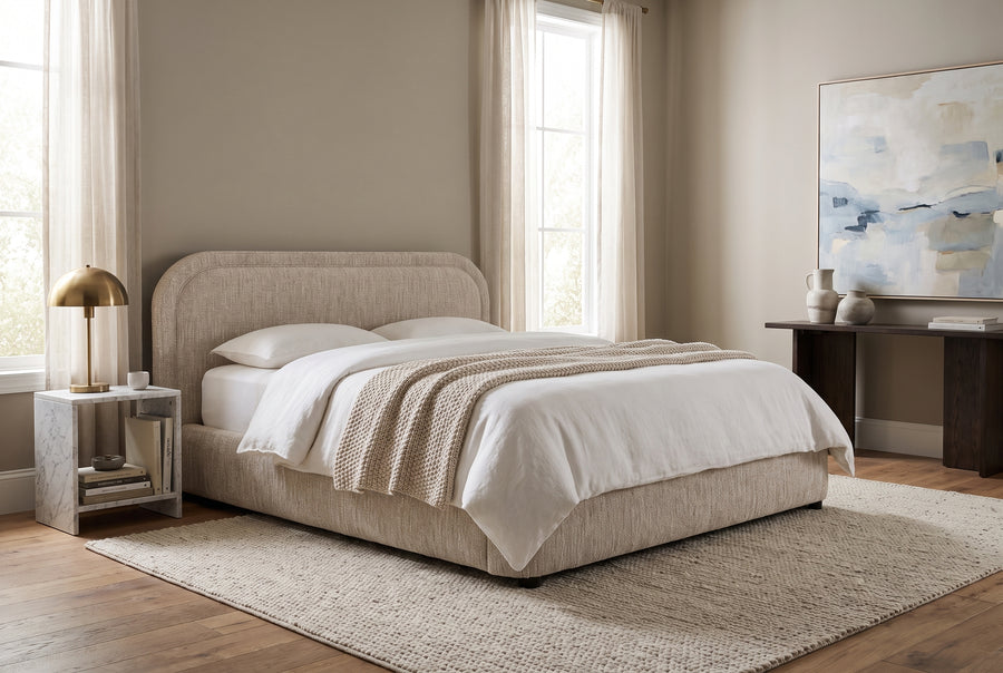 Modern minimalist bedroom featuring a beige upholstered bed, marble side table, and abstract art in a neutral palette.