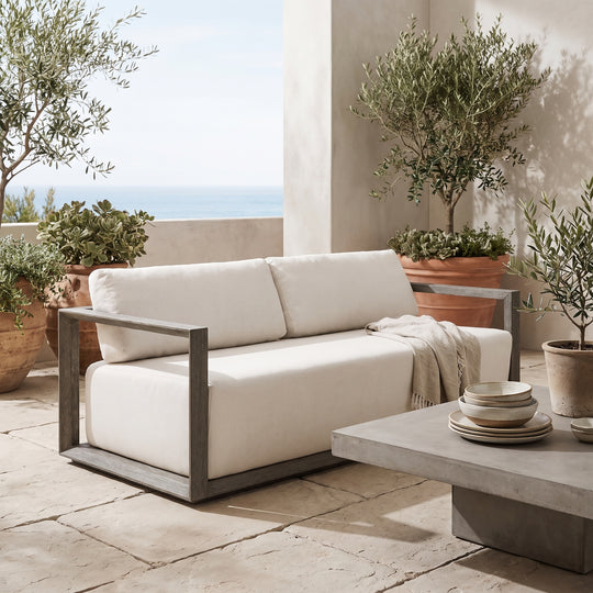 sofa with off-white fabric cushions and a weathered gray-brown wooden frame