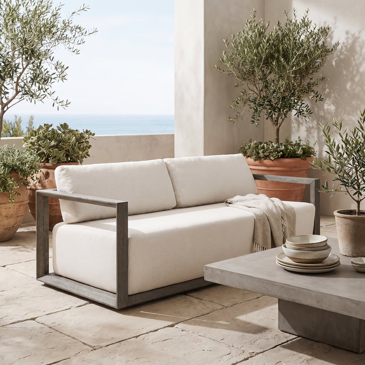 sofa with off-white fabric cushions and a weathered gray-brown wooden frame