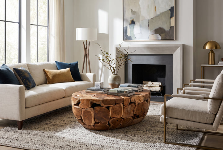 Modern living room featuring a rustic teak wood coffee table, cream sofa, and fireplace in a sophisticated, neutral space.