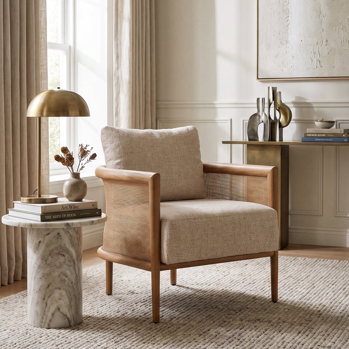 Odette Cane Paneled Accent Chair in a neutral, sunlit living room with a marble side table and elegant decor.